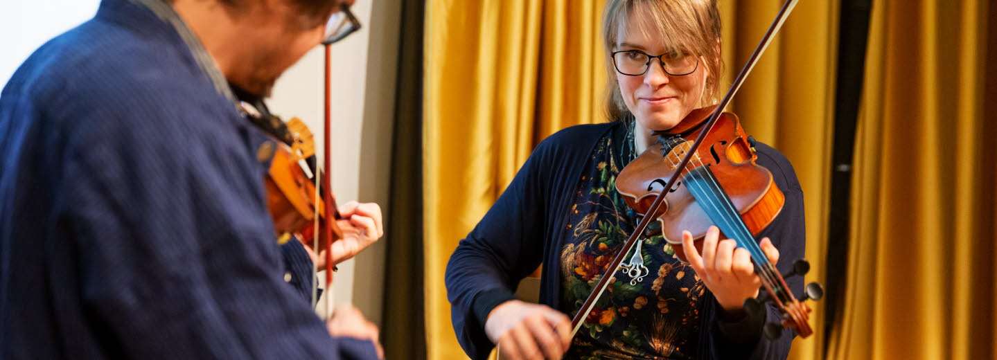 Two people playing the violin.