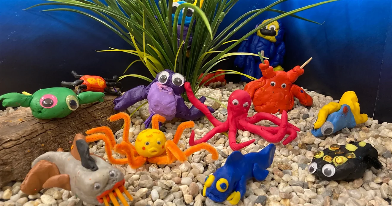 Fantastifulla undervattensdjur skapade i lera av barn.