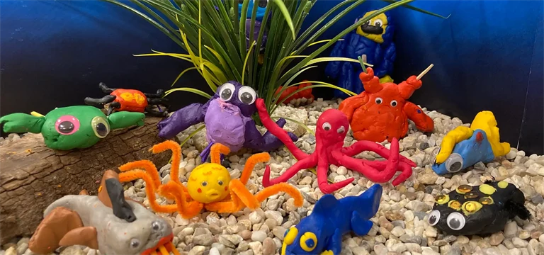 Fantastifulla undervattensdjur skapade i lera av barn.