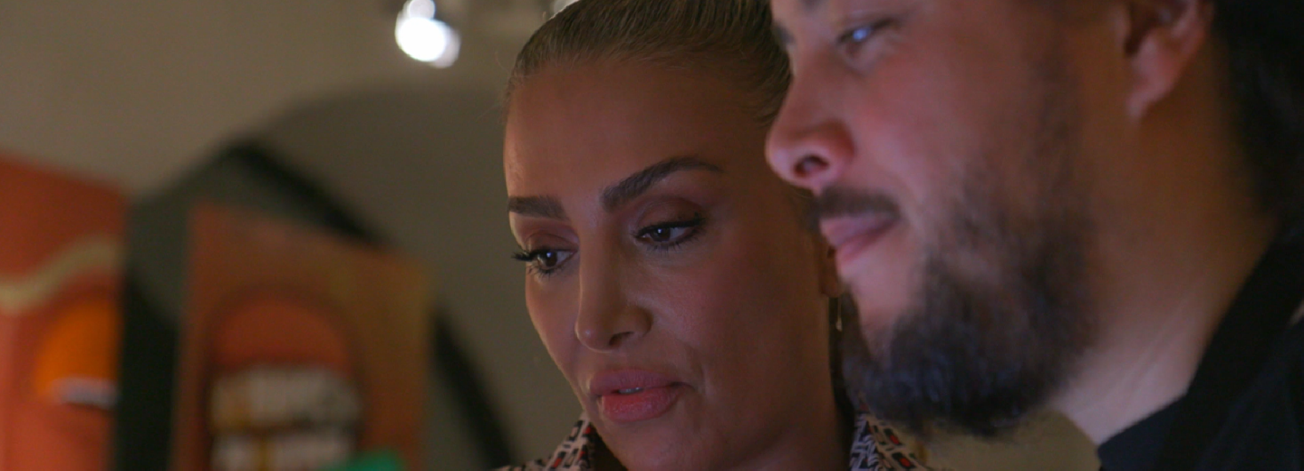 Närbild av en kvinna och en man som tittar ner på något utanför bilden.