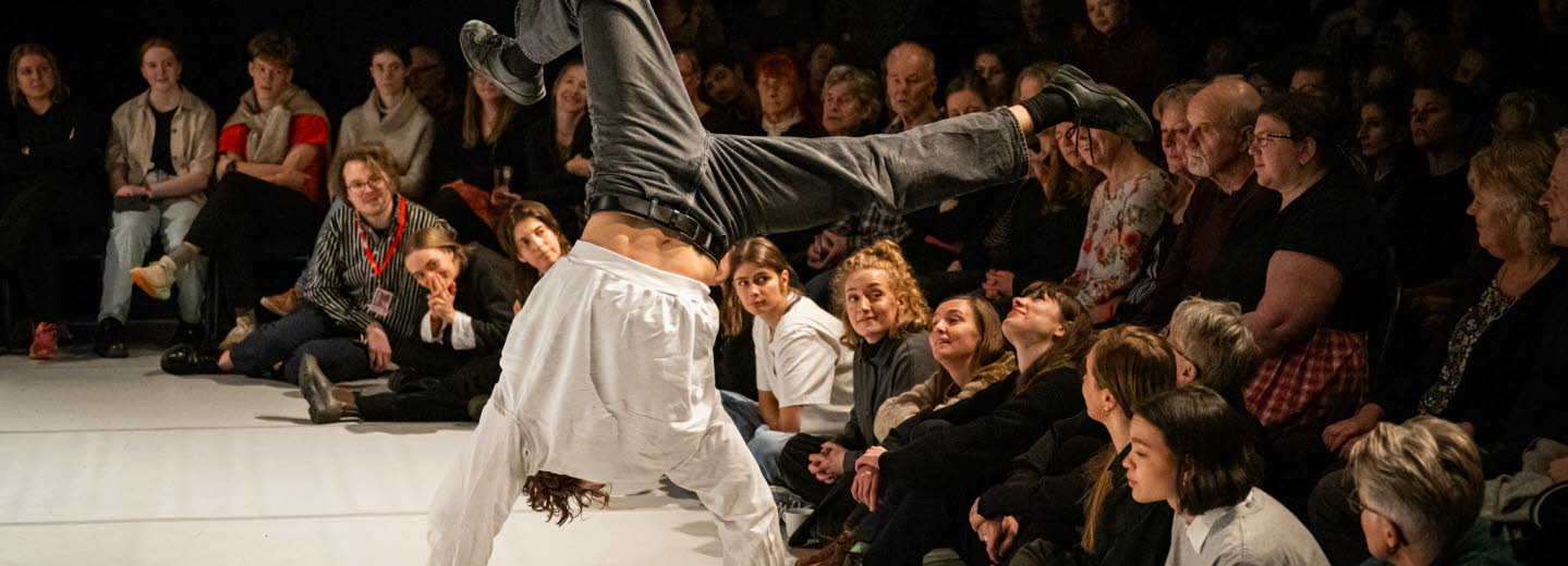 Kille står på händer inför en publik.