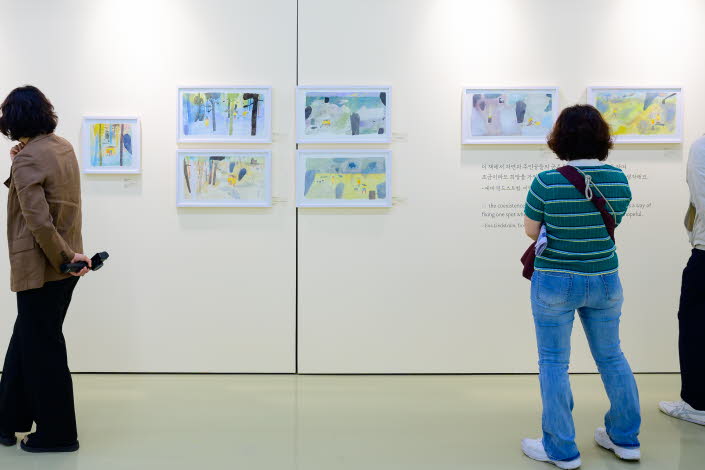 Tre personer tittar på en utställning med teckningar av Eva Lindström under Jeonju internationella bilderboksmässa 2025. Three people are viewing an exhibition of drawings by Eva Lindström at the Jeonju International Picture Book Fair 2025.