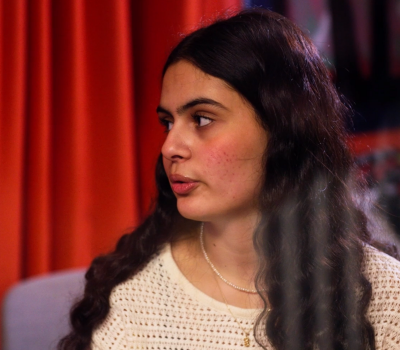 En kvinna som står framför ett draperi.