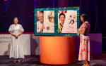 Bild från en scen med tre kvinnor. Författaren Jacqueline Woodson tar emot sitt diplom från kronsprinsessan Victoria i maj 2018.. I bakgrunder applåderar dåvarande kulturminister Alice Bah Kuhnke.