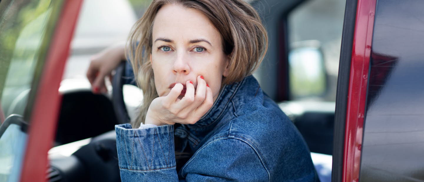 Portrait of Annika Norling sitting in a red car. 