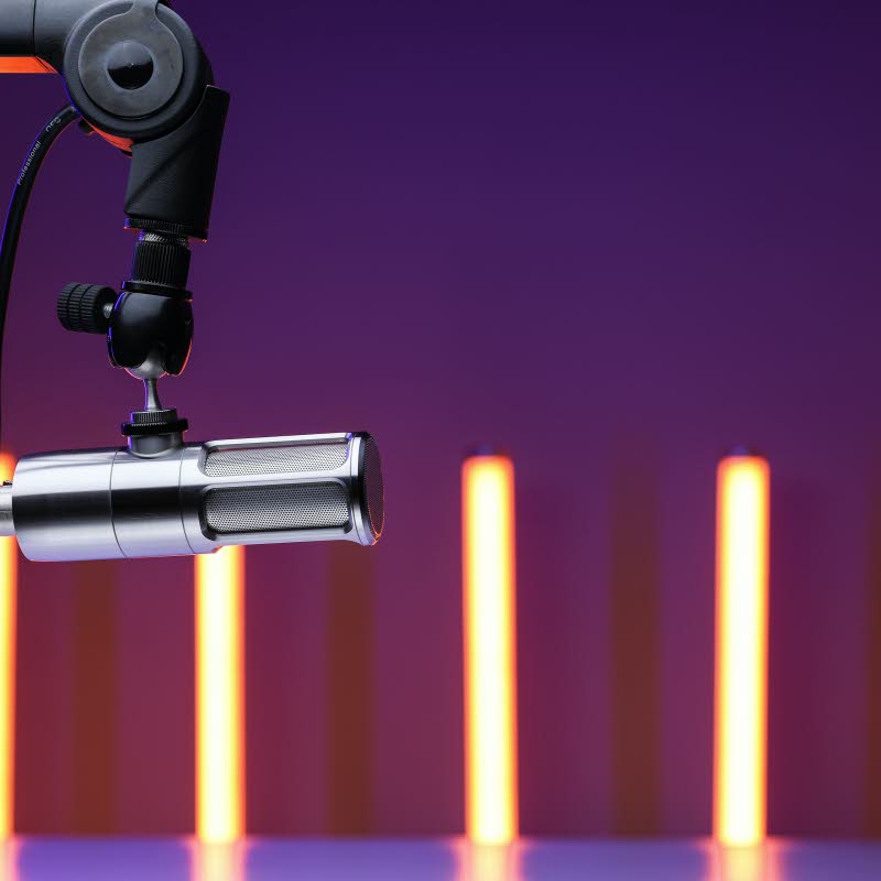 Foto på mikrofon. Smala ljuspelare i bakgrunden.