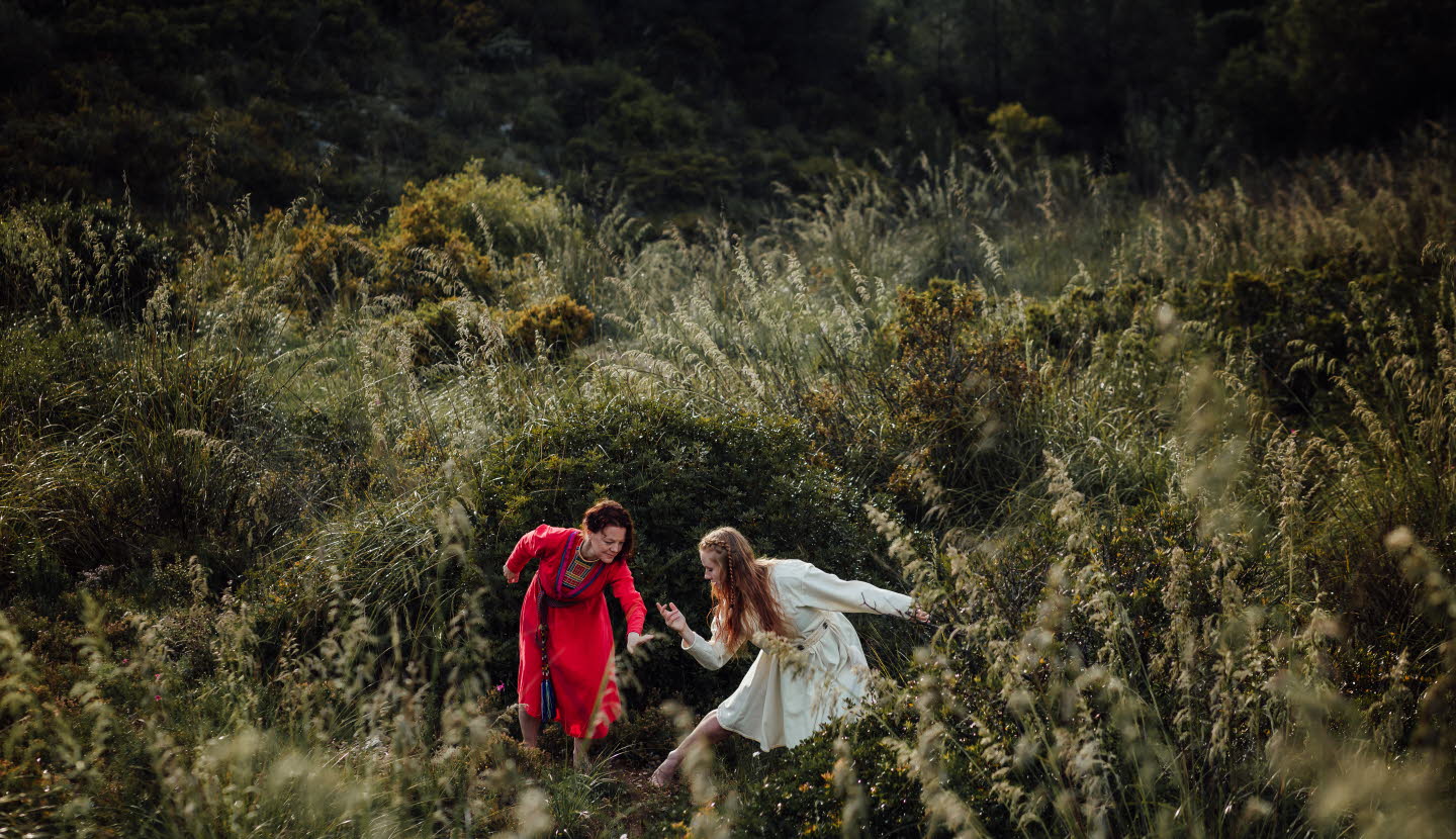 The dancer Liv Aira and jojk artist Elin Teilus performing in a field.