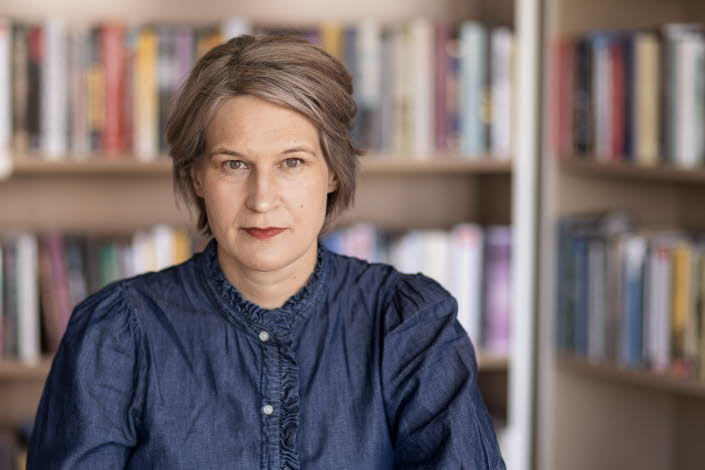 Porträttfotografi av en medelålders kvinna, Kulturrådets generaldirektör. I bakgrunden bokhyllor med böcker.