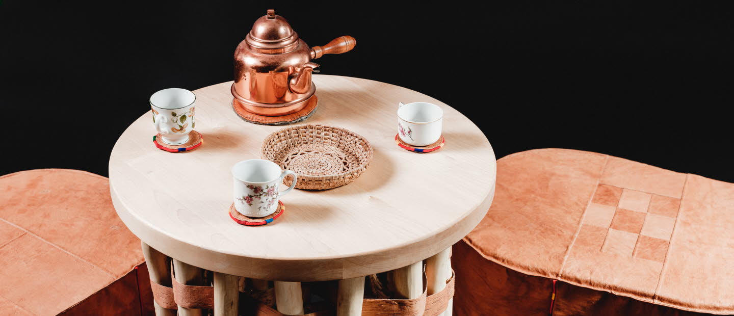 Duodje, samiskt hantverk, ett bord och pallar i trä. på bordet står det en kaffeservis.