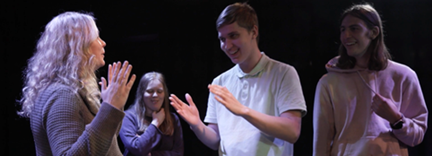 Fyra personer agerar på en scen. 