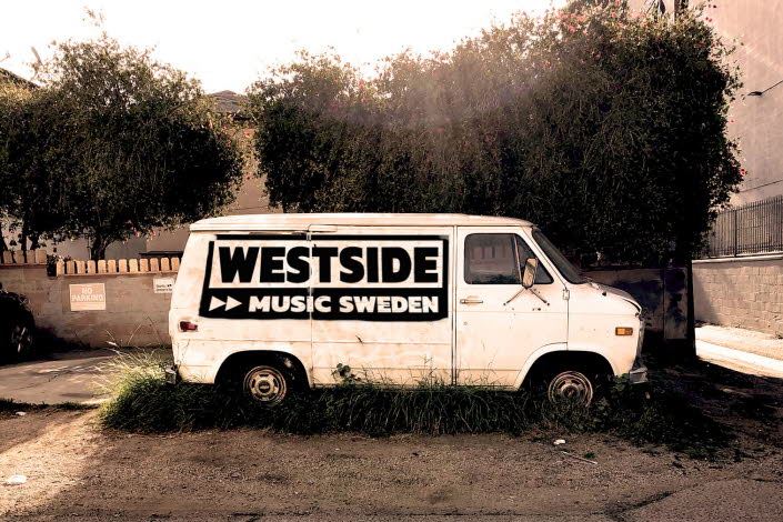 Bild på en vit van med texten "Westside, Music Sweden". Mjuk svart-vit färgskala i brun ton.