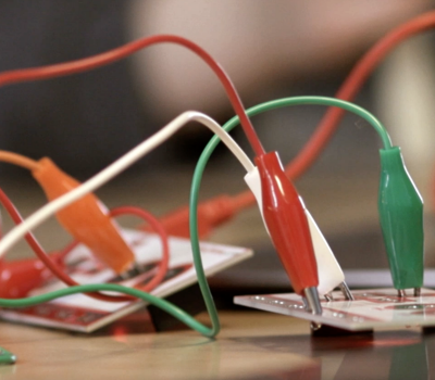 Elsladdar i olika färger som sitter inkopplade i eluttag.