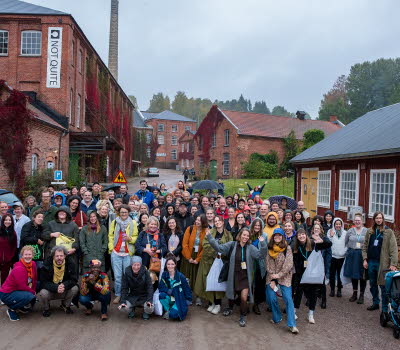 Gruppbild på nätverket utomhus mellan tegelhus och ett trähus.