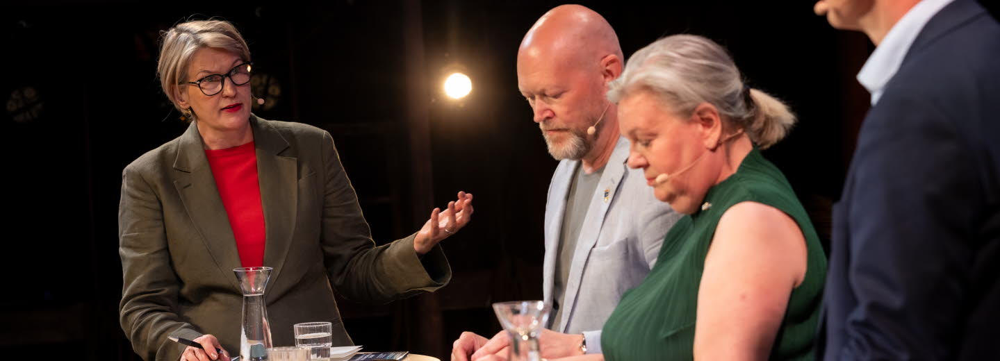 Fyra personer i samtal på en scen.