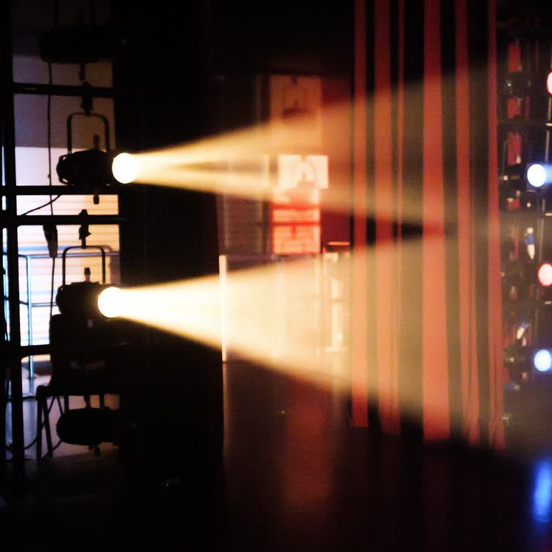 Scen belyst med gult, blått och rött ljus.