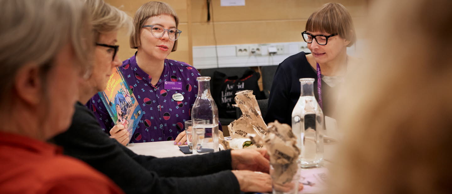 A group of women sitting at a table and talking.