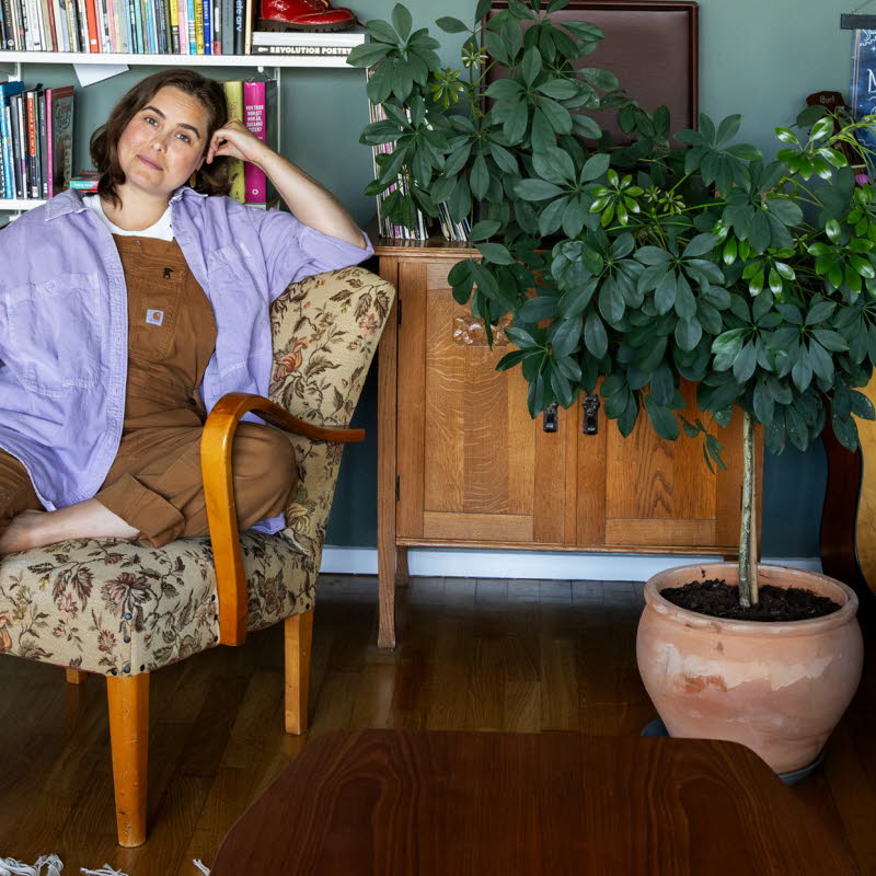 Läsambassadören Agnes Török i en fåtölj framför en bokhylla.