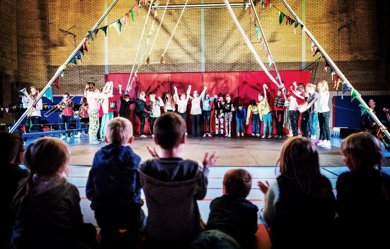 Barn uppträder med cirkus på en scen