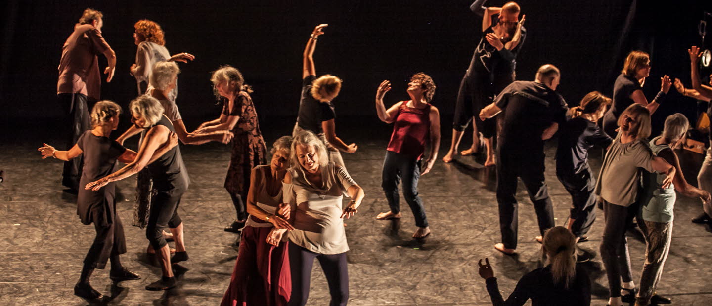 Äldre människor dansar tillsammans på en scen.