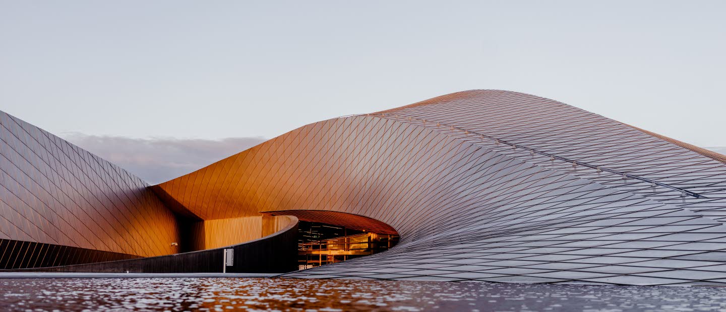 Böljande byggnad som ser ut som en sandbänk.