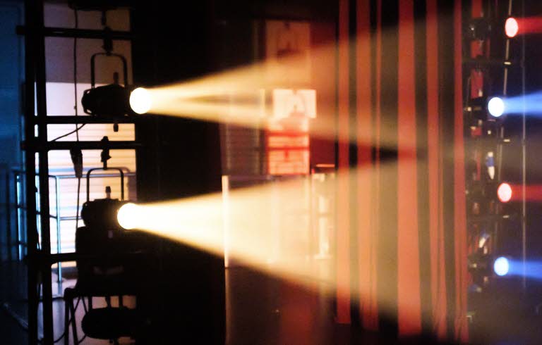 Scen belyst med gult, blått och rött ljus.