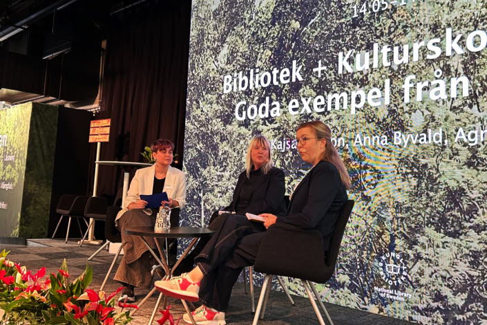 Tre personer sitter på en scen och samtalar.