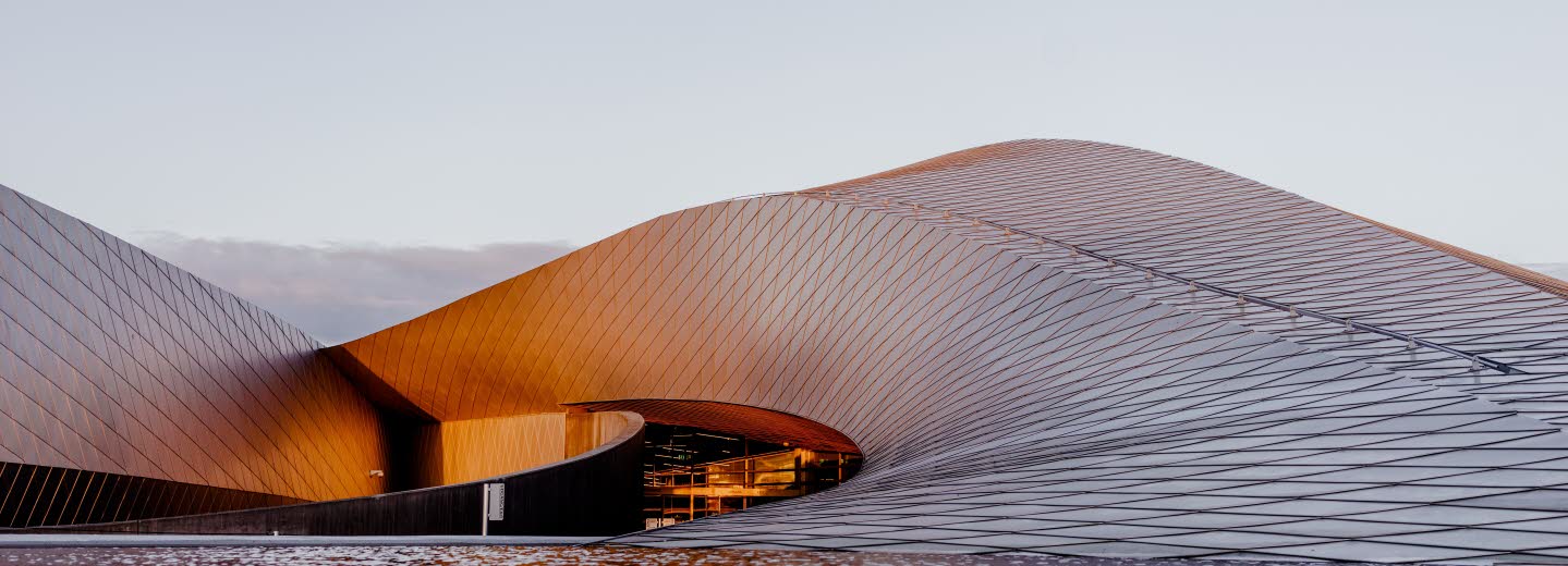 Böljande byggnad som ser ut som en sandbänk.