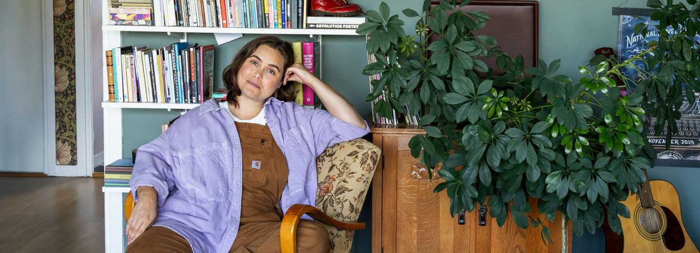 Läsambassadören Agnes Török i en fåtölj framför en bokhylla.