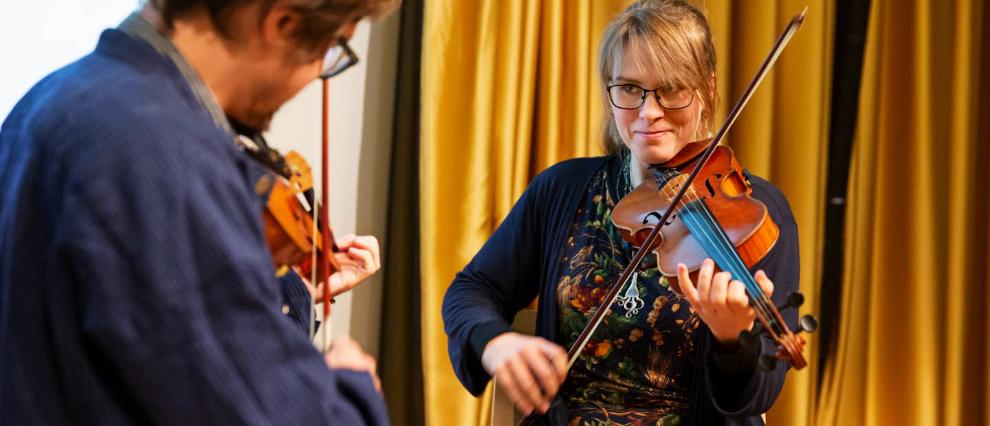 Two people playing the violin.