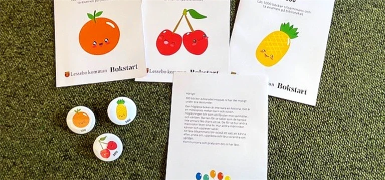 Foldrar och pins med glada frukter från projektet 1000 böcker för F-klass.