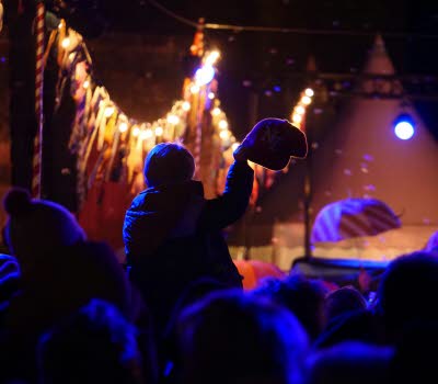 Publik framför en scen i dunkel lila beslysning.