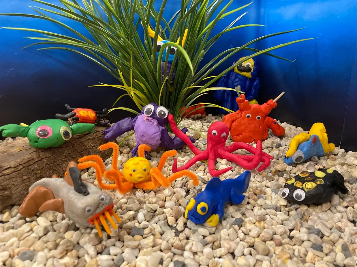 Fantastifulla undervattensdjur skapade i lera av barn.