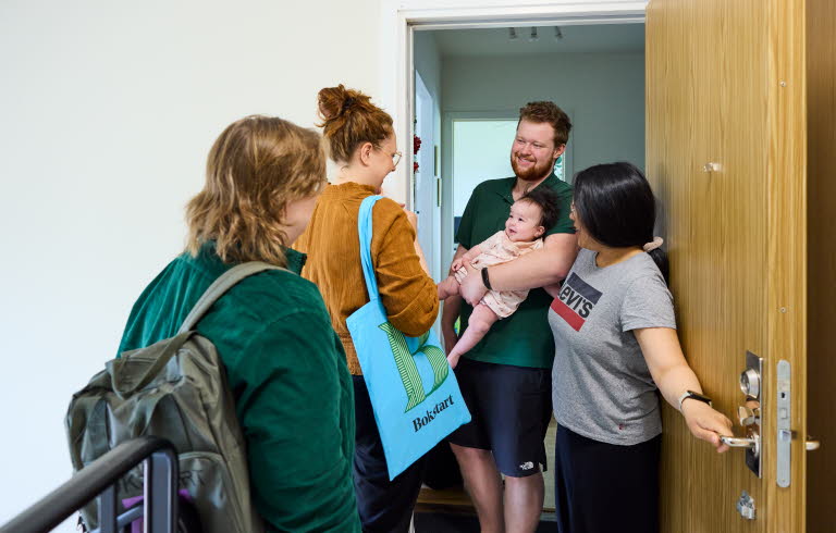 Två medarbetare som arbetar med Bokstart gör ett hembesök. Möter en familj i trapphuset.