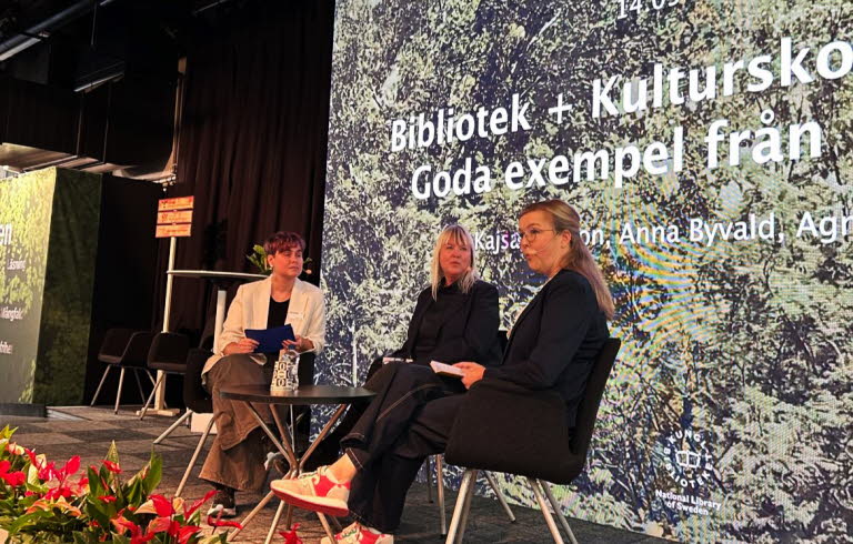 Tre personer sitter på en scen och samtalar.