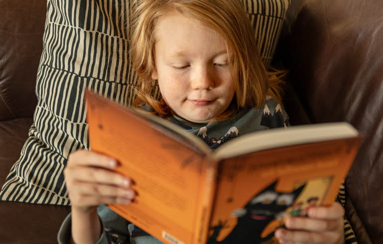 En pojke som läser en bok. Foto: Susanne Kronholm.