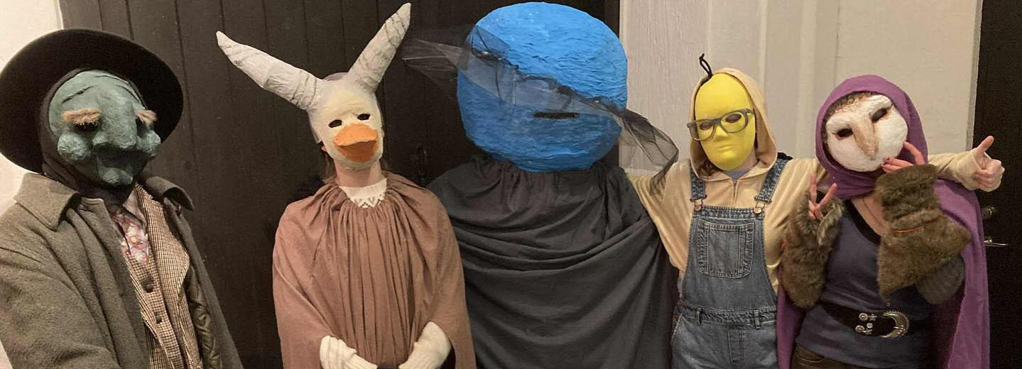 Fem undomar i masker och kostymer.
