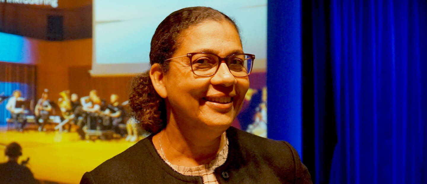 Bild på Sophia Alexandersson, med en orkester i bakgrunden. 