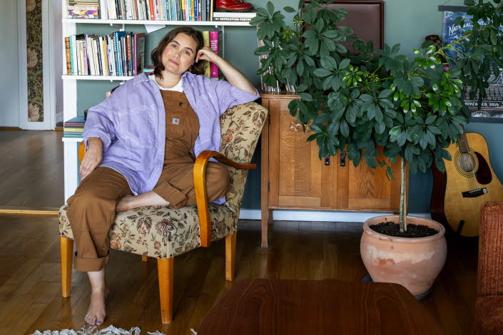 Läsambassadören Agnes Török i en fåtölj framför en bokhylla.