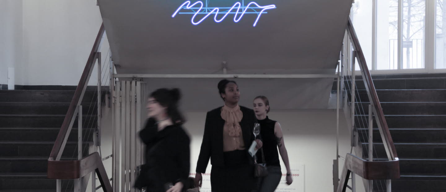 Människor är på väg uppför en trappa. Ovanför står det "Mint" i neon.