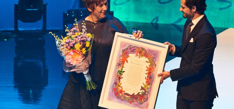 Marion Brunet står på en scen tillsammans med H.K.H. Prins Carl Philip.