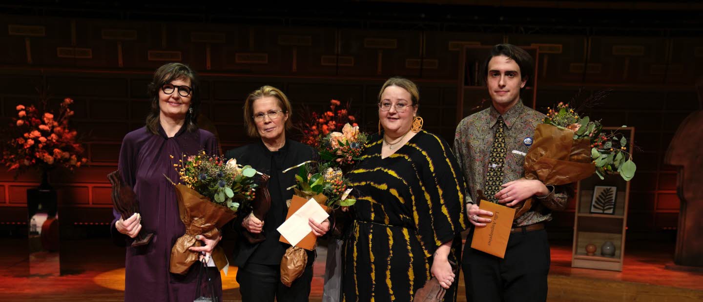 The four laureates stands together with flowers in their hands.