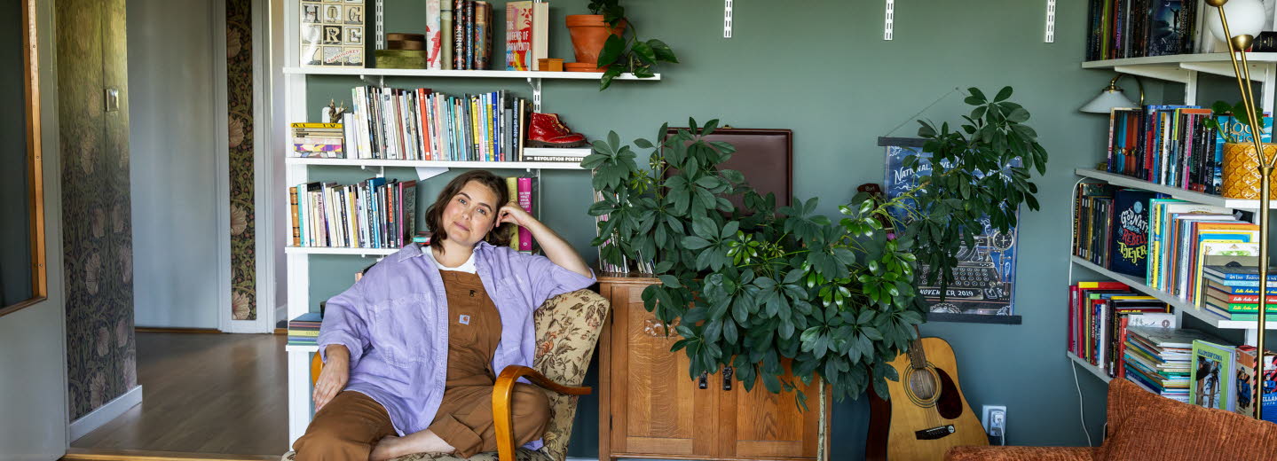 Läsambassadören Agnes Török i en fåtölj framför en bokhylla.