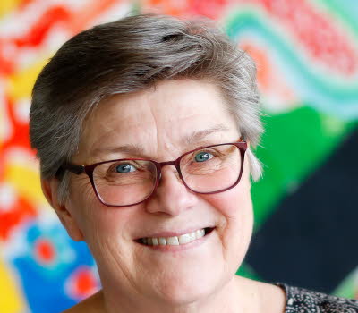 Maria Becker Gruvstedt fotograferad mot en färgglad bakgrund