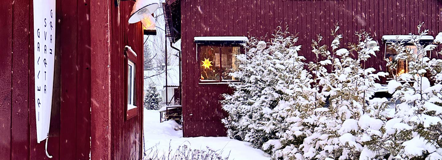 Två röda hus i vinterlandskap.