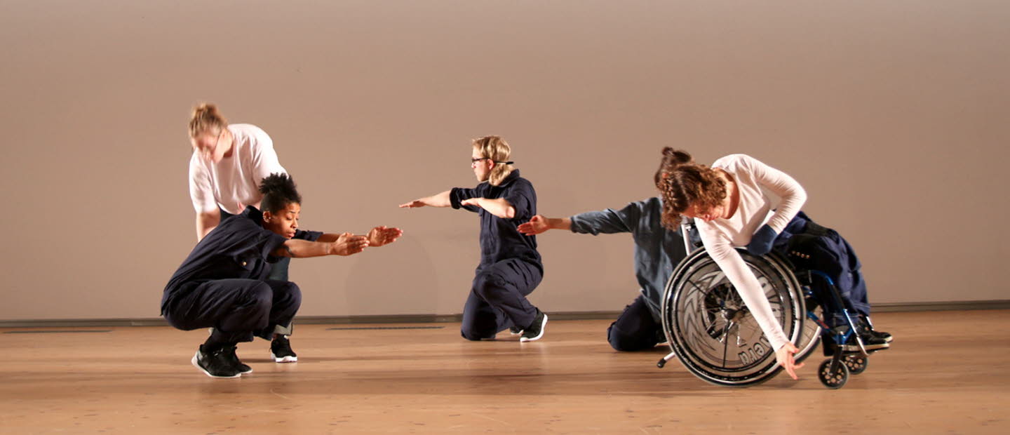 Dansverket WORK av ShareMusic & Performing Arts. Dansare på scen, ena dansaren i rullstol, de andra står på huk.