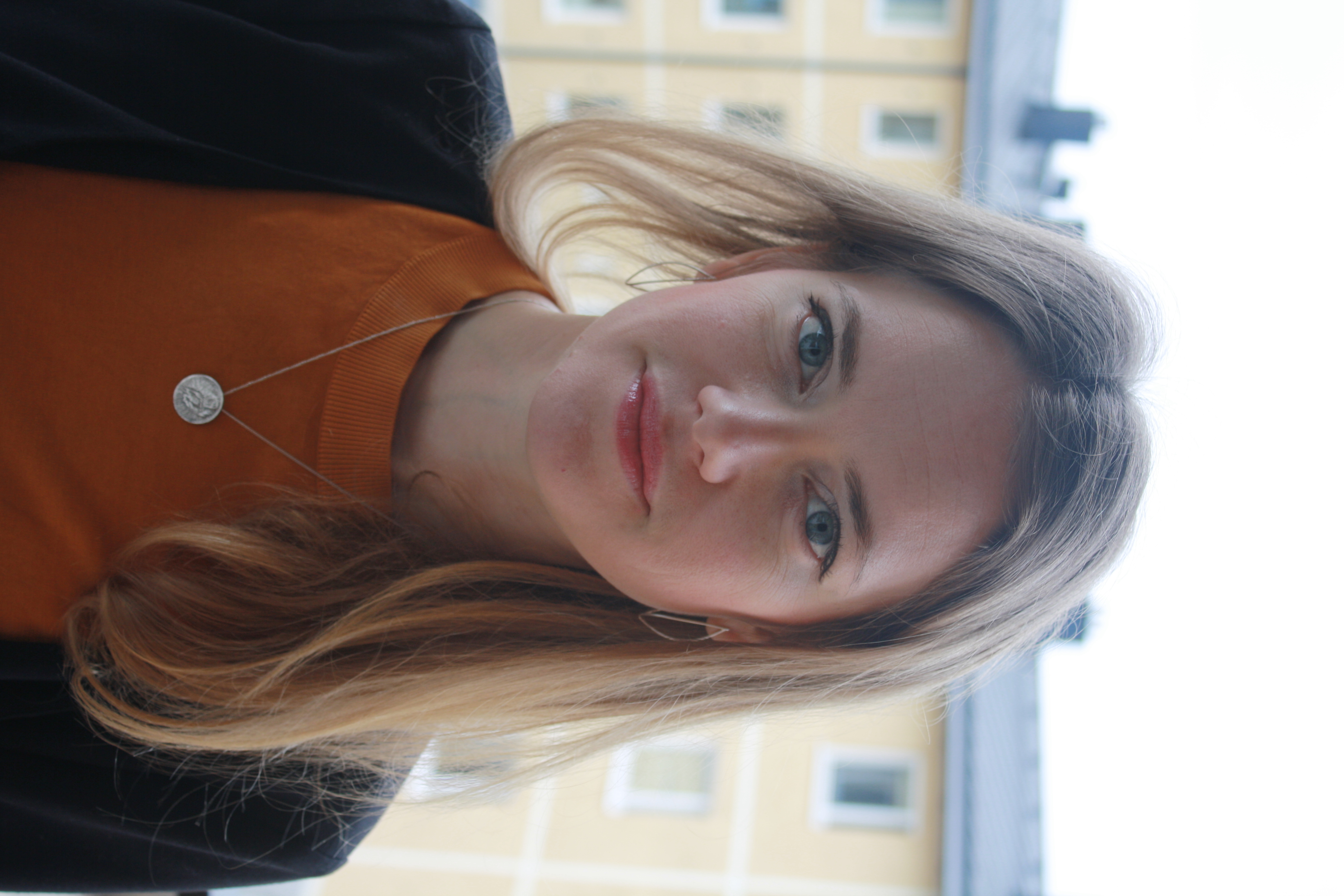 A young woman with brown hair is looking towards the camera. 