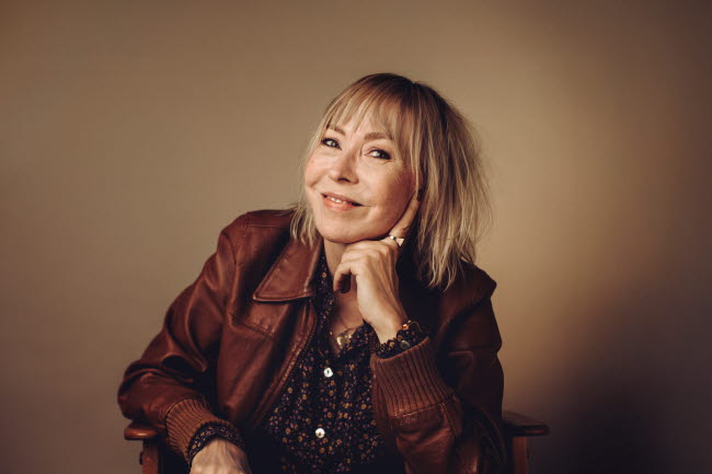 Kvinna sitter i karmstol, fotografi.