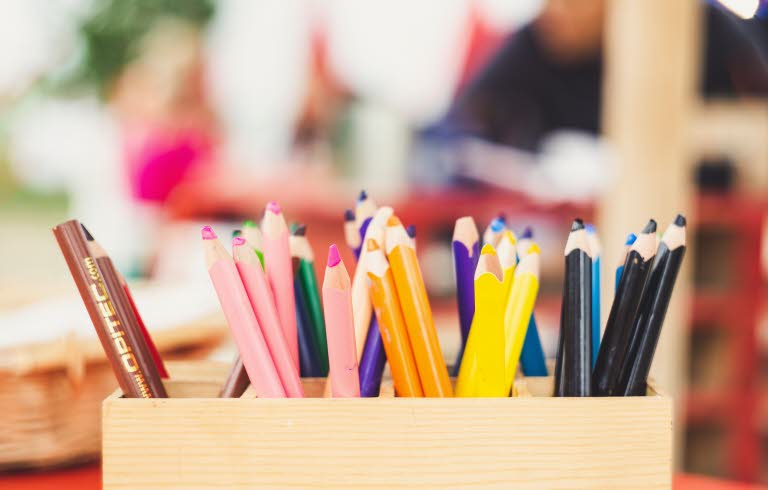 Närbild på ett pennställ innehållandes pennor för barn.