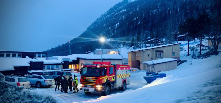 Vinterbild med människor som samtalar bredvid en brandbil.