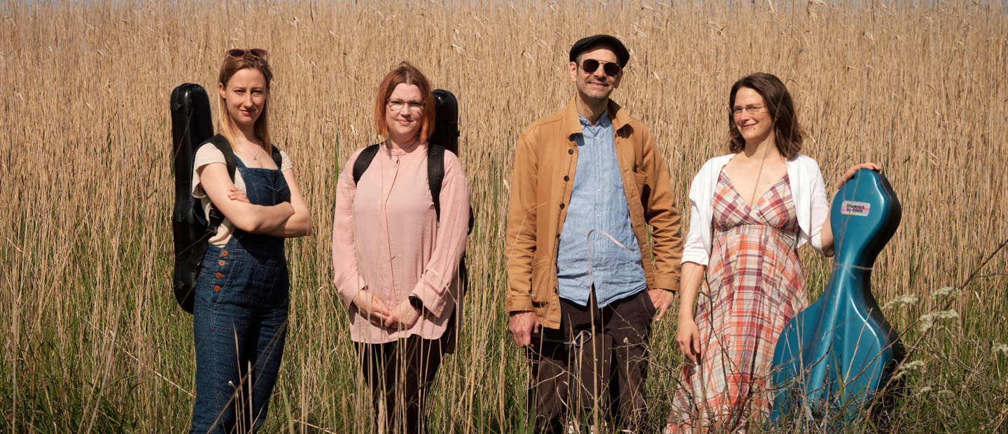 Fyra musiker i utomhusmiljö.